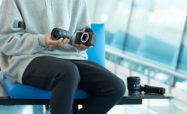 Imagine cu un barbat schimband obiectivul de pe camera